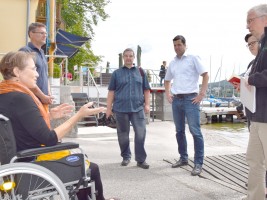 Brigitta Wintersteiger (im Rollstuhl),  hinter ihr Günter Honisch und Bürgermeister Stefan Krapf (3.v.r.) mit Medienvertretern im Gmundner Yachtclub 
