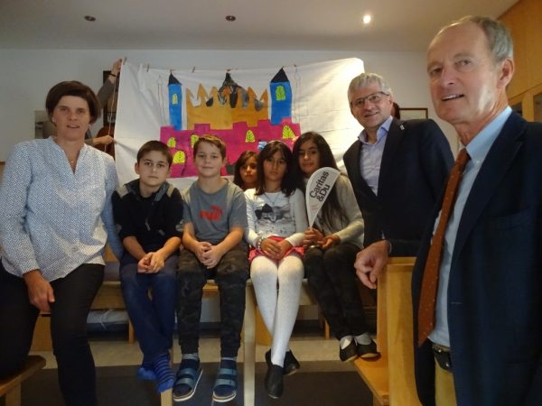 Caritas-Lerncafé-Leiterin DI Christine Schön (links), Caritasdirektor Franz Kehrer, MAS (rechts oben) und Bürgermeister Mag. Herbert Brunnsteiner mit Kindern bei der Eröffnungsfeier.